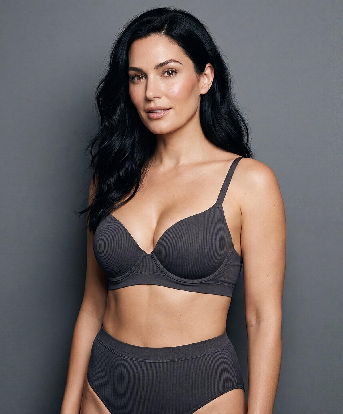 Model in dark lingerie against gray background