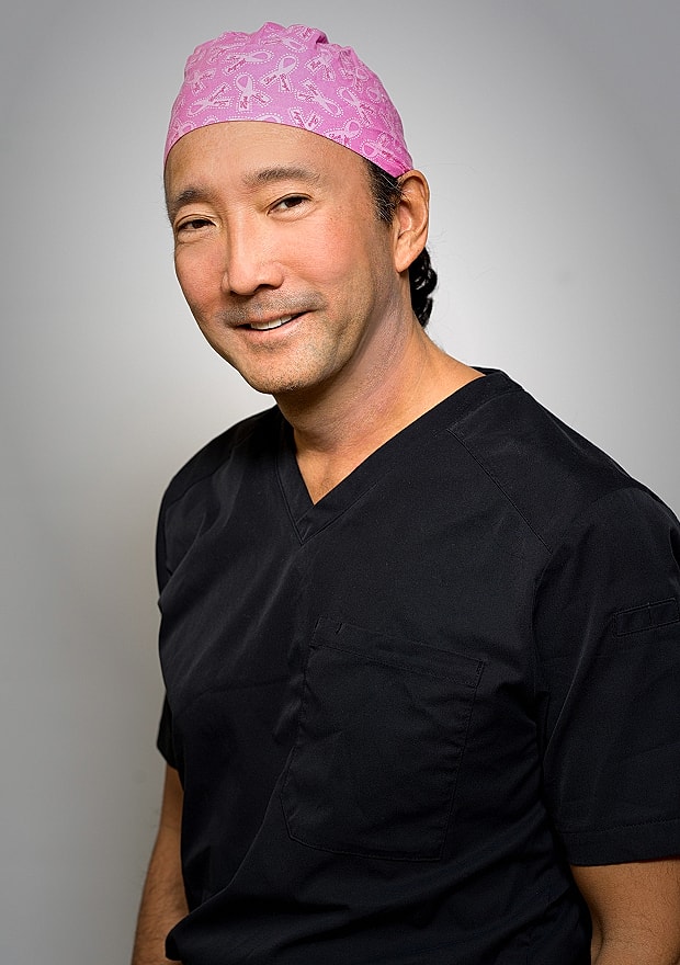 Smiling medical professional in scrubs and headband.