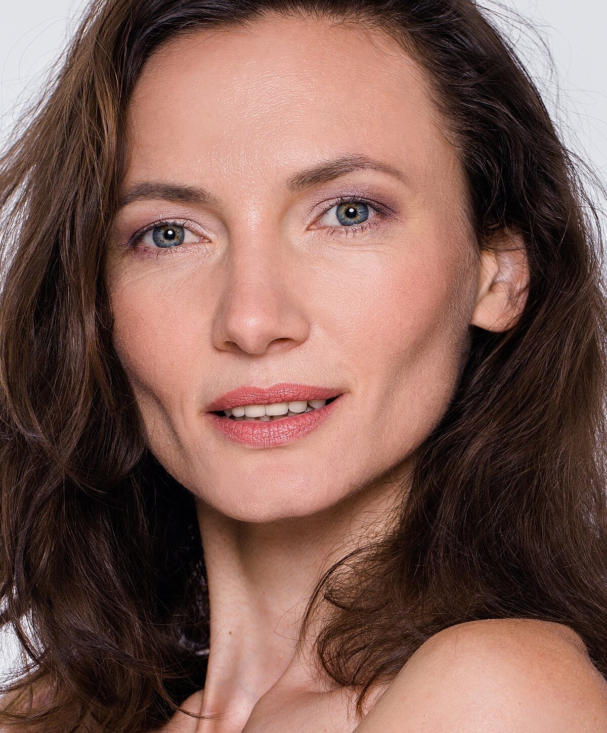 Smiling woman with long, wavy hair.
