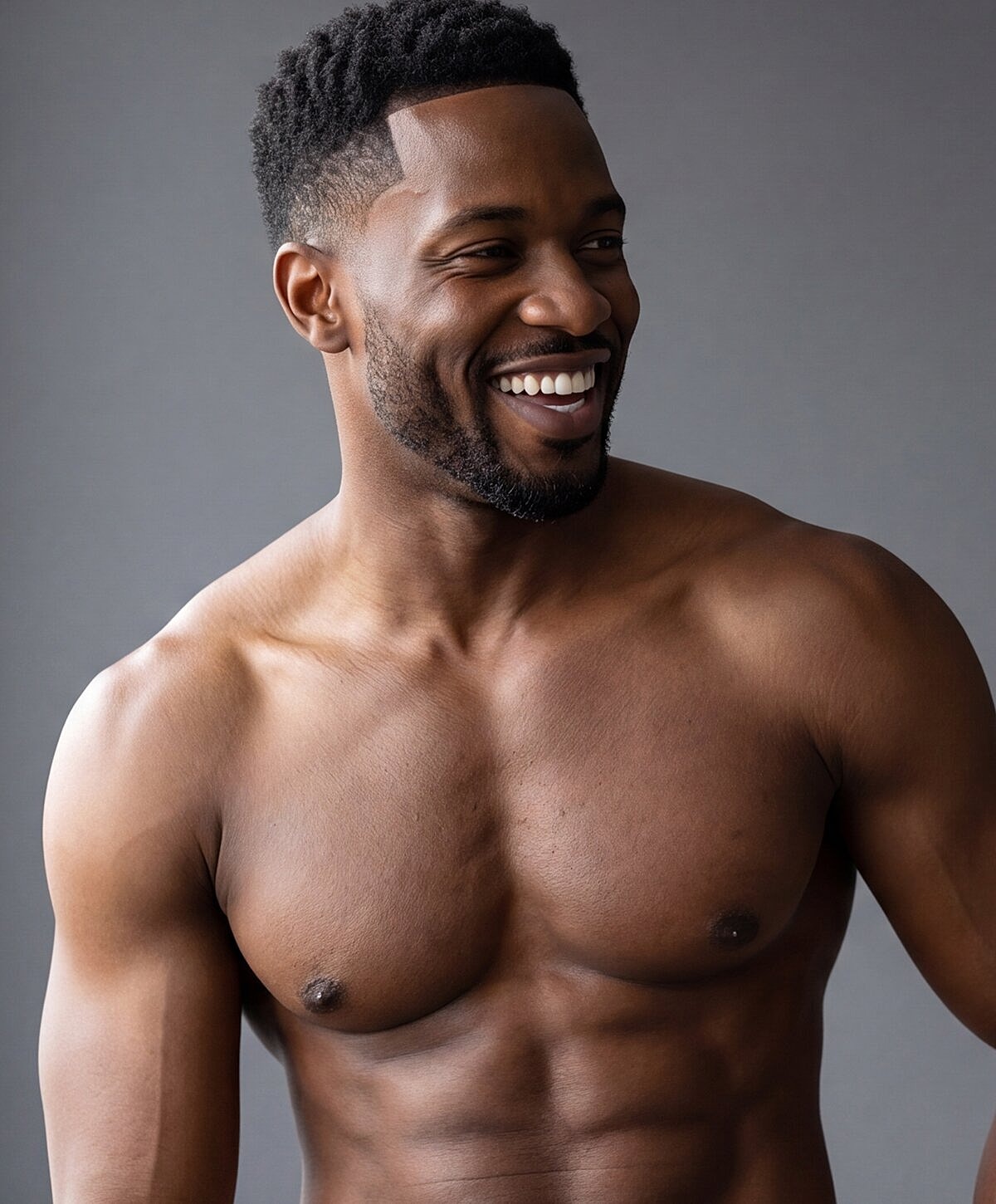 Smiling man with a toned physique against gray background.