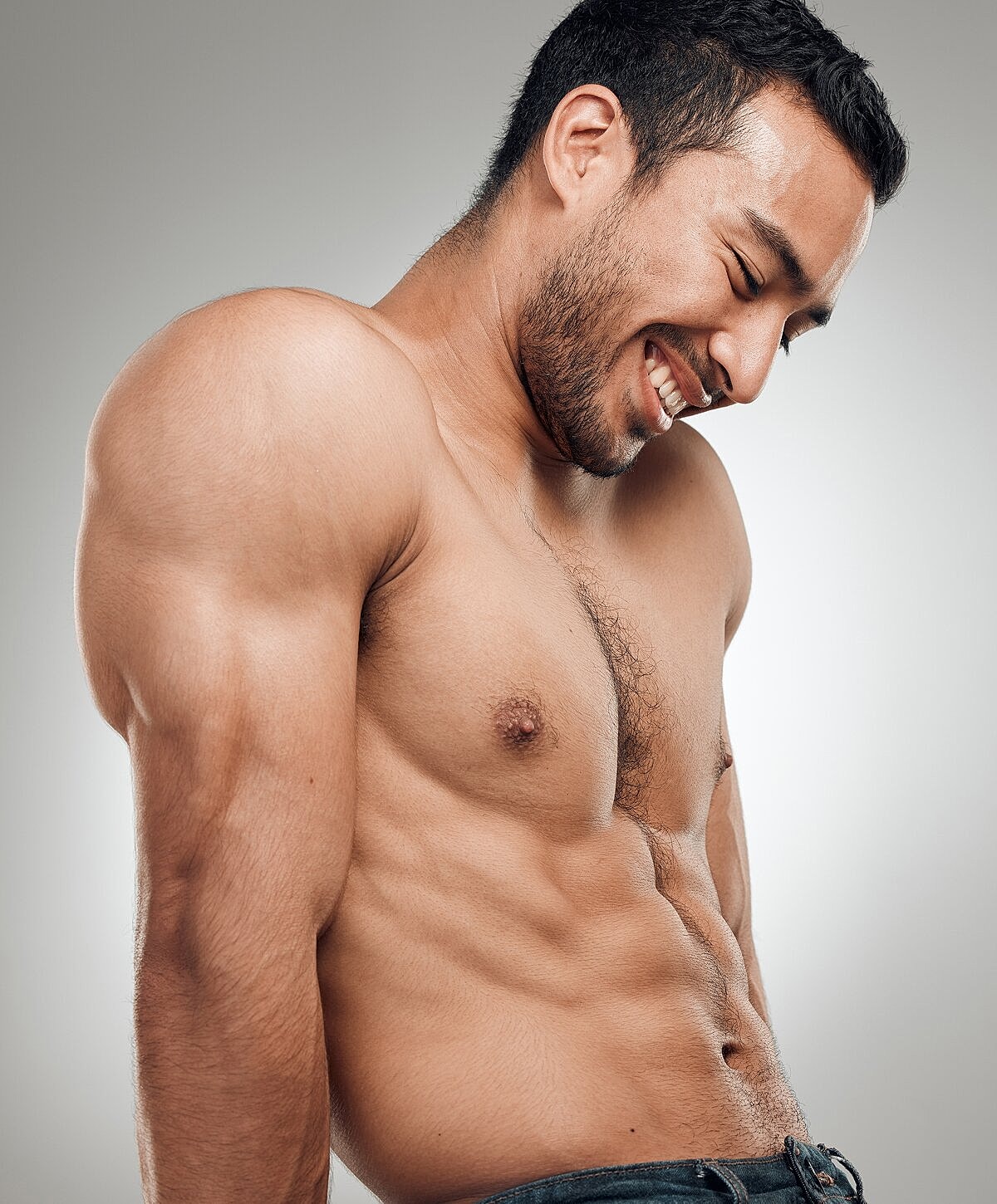 Smiling man showing strong physique and abs.