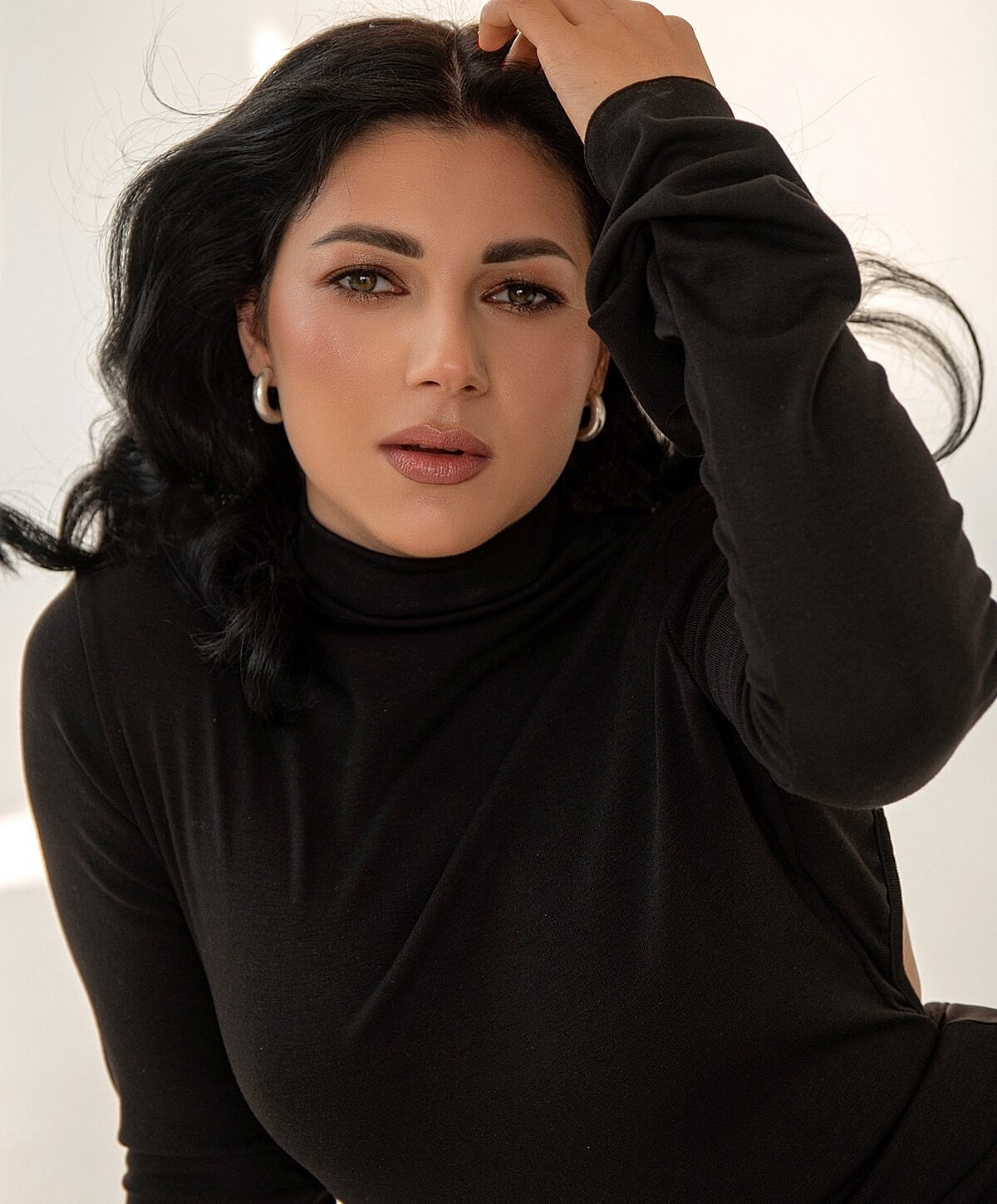 Woman with dark hair in a stylish black top.