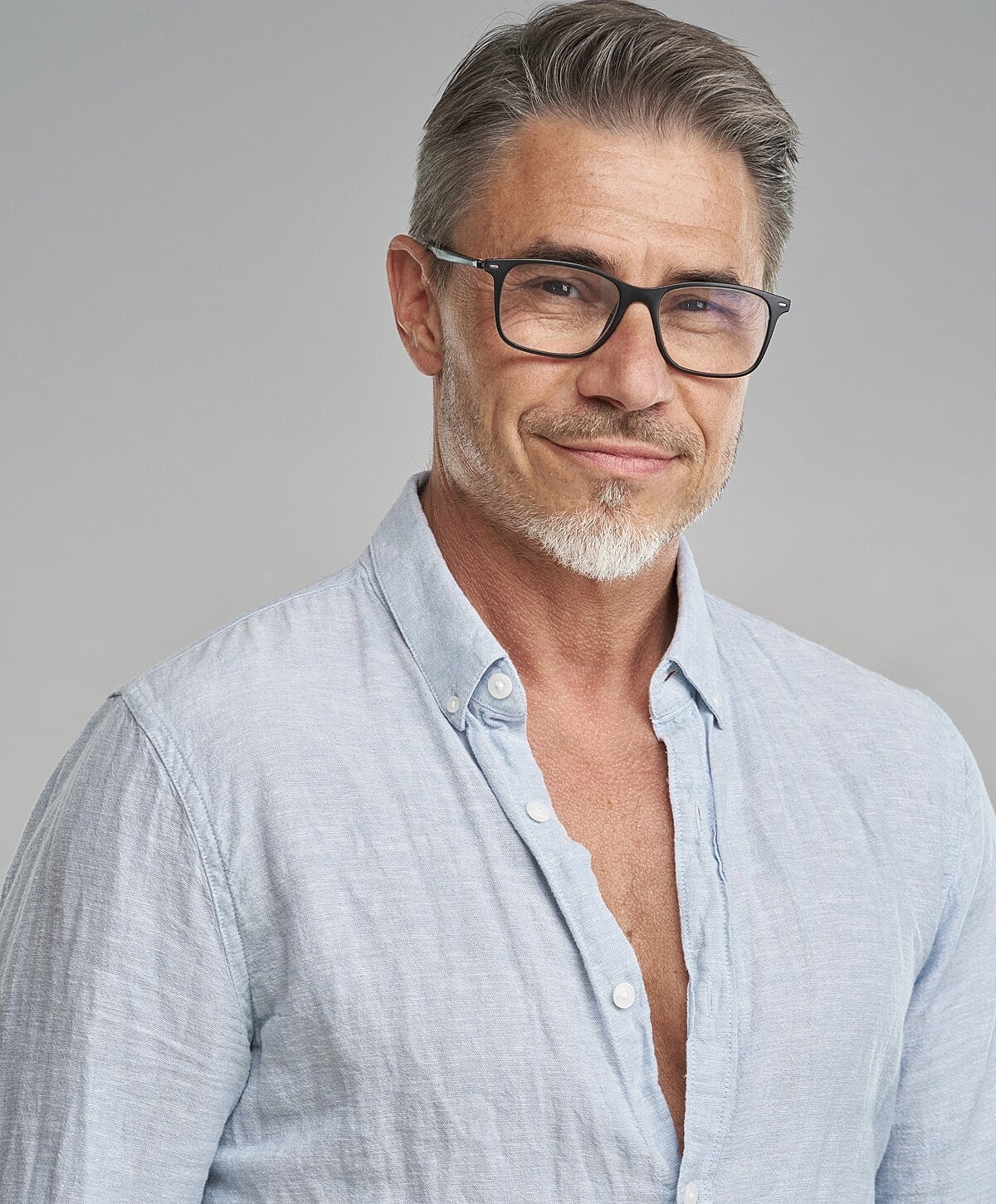 Smiling man in glasses wearing casual shirt.