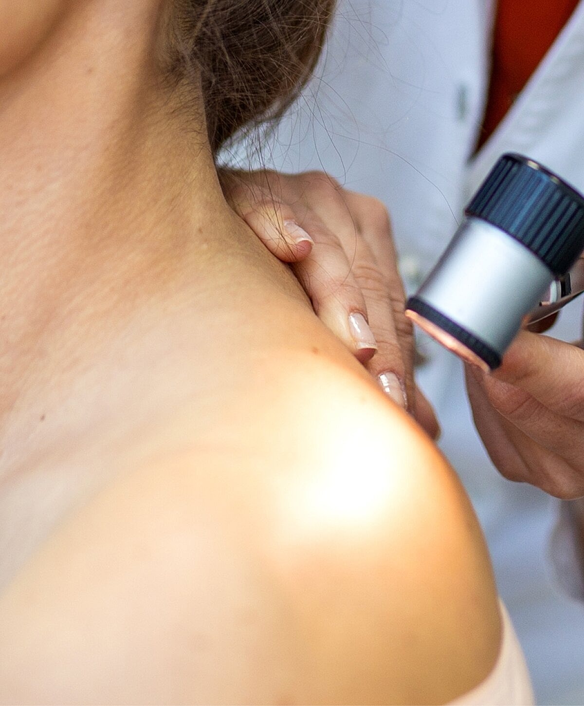 Skin examination with handheld device by professional.