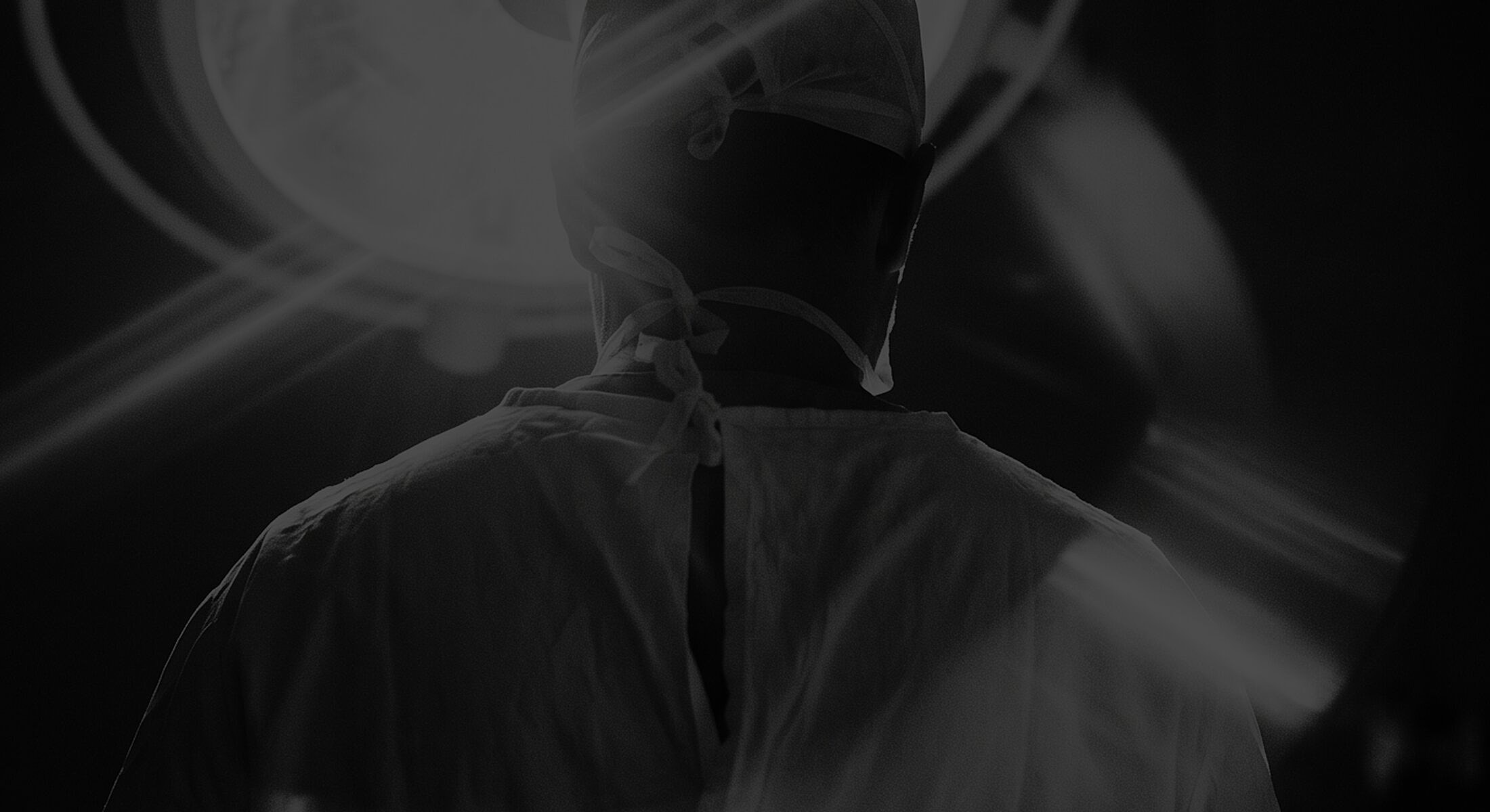 Surgeon preparing for surgery in dim lighting.