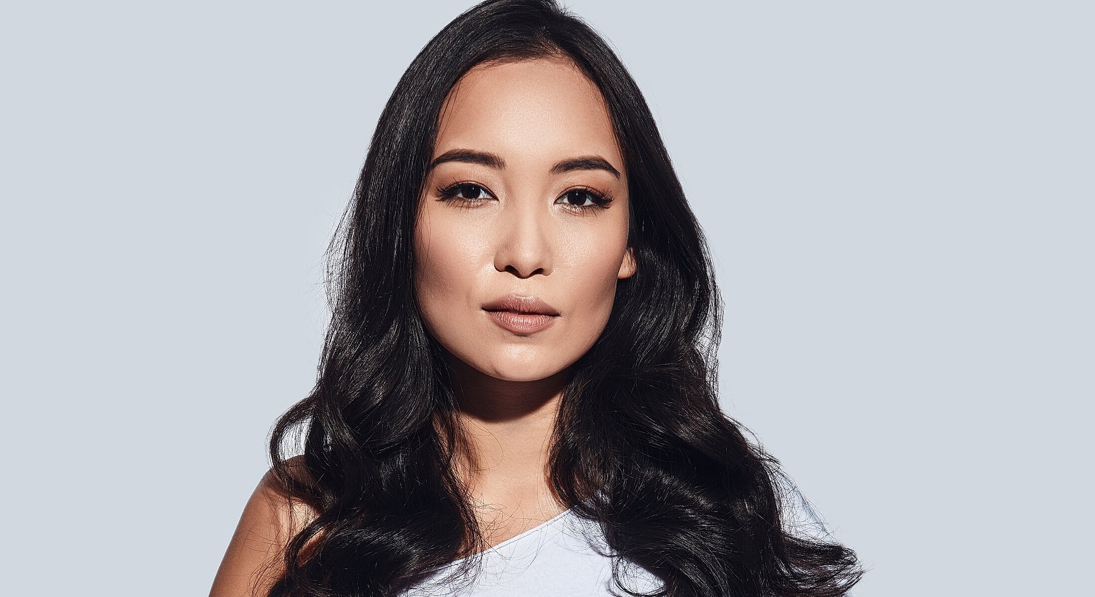 Woman with long black hair and natural makeup.