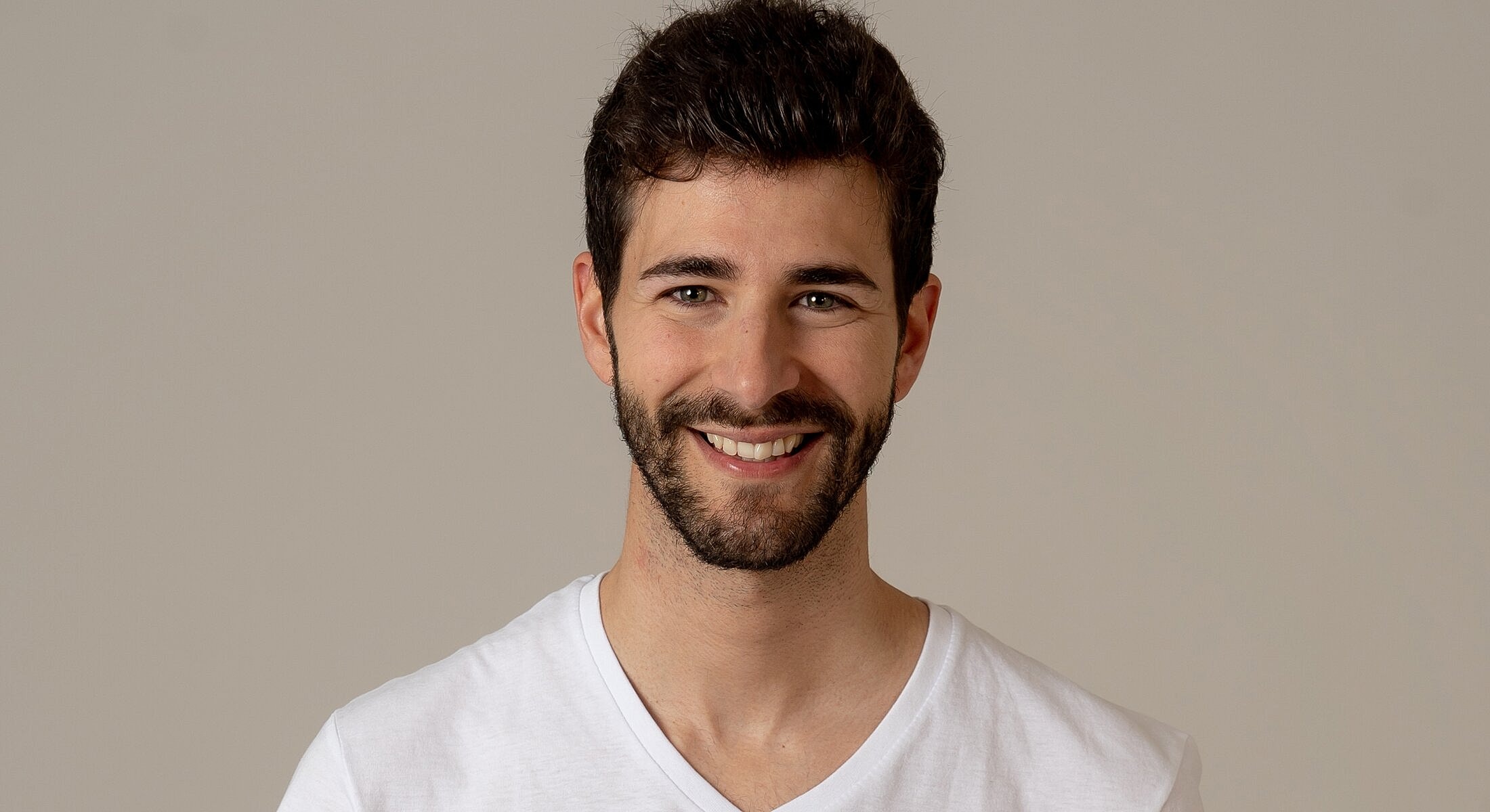 Smiling man in a white shirt on gray background