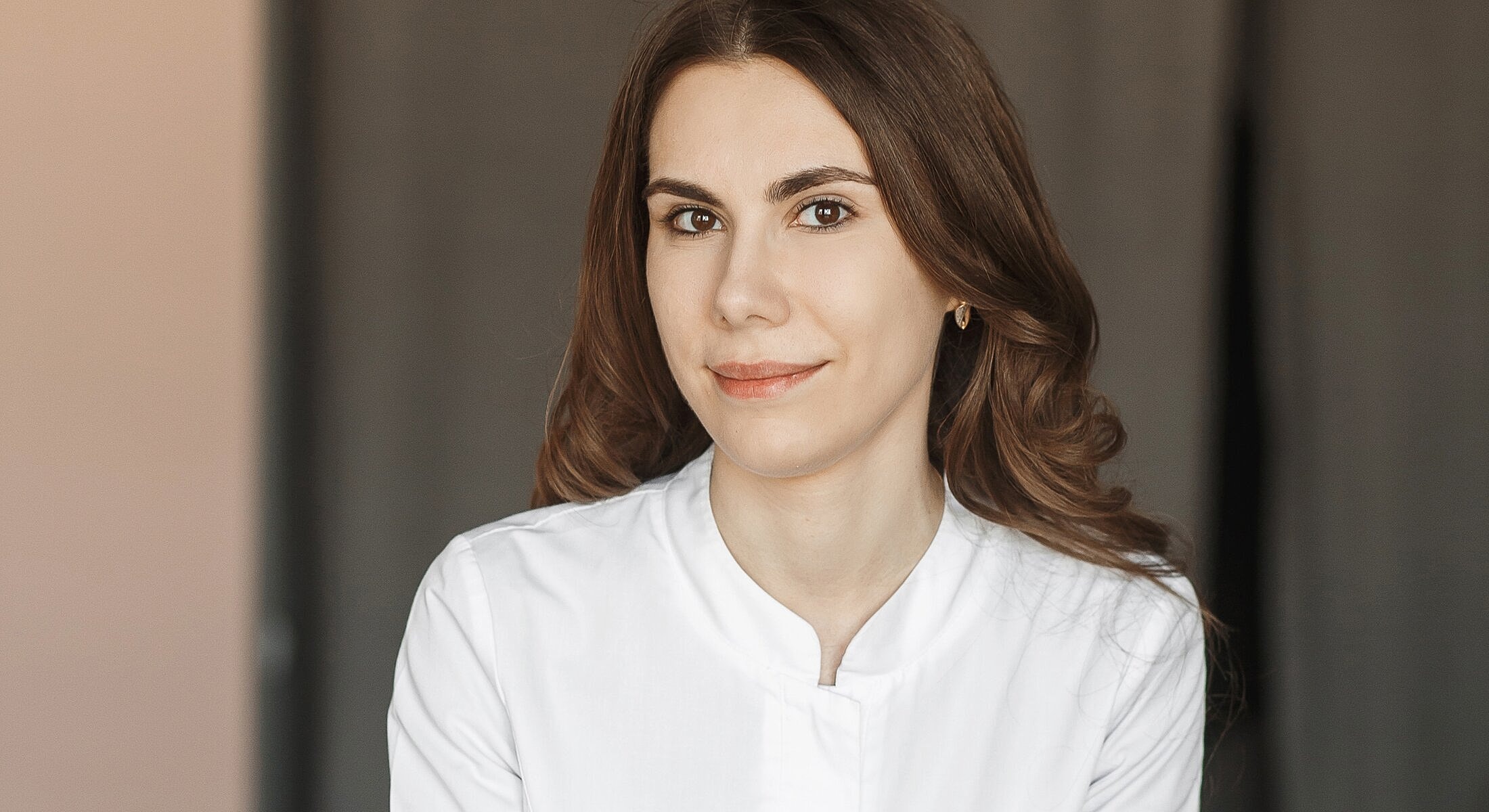 Woman wearing white shirt, smiling at camera.